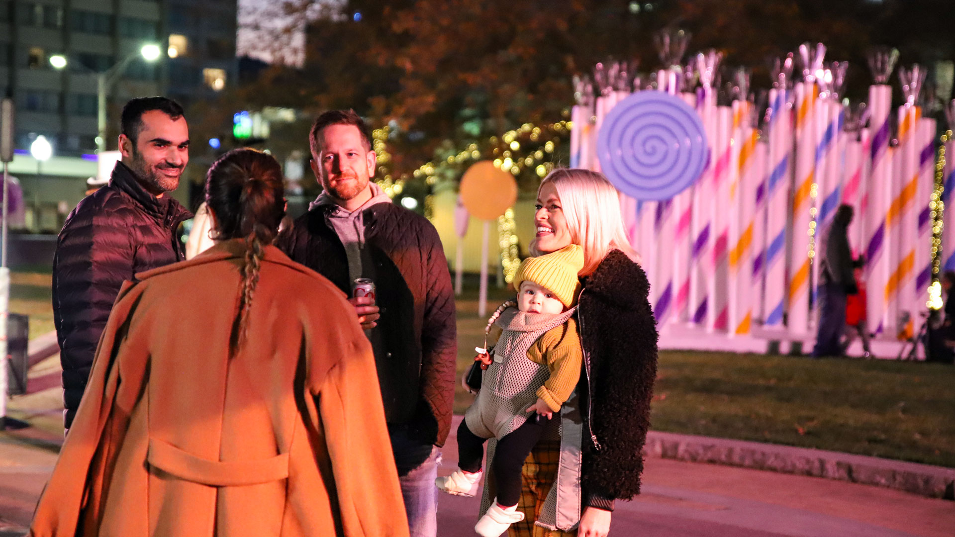 Family conversing in front of installation at Candy Lane