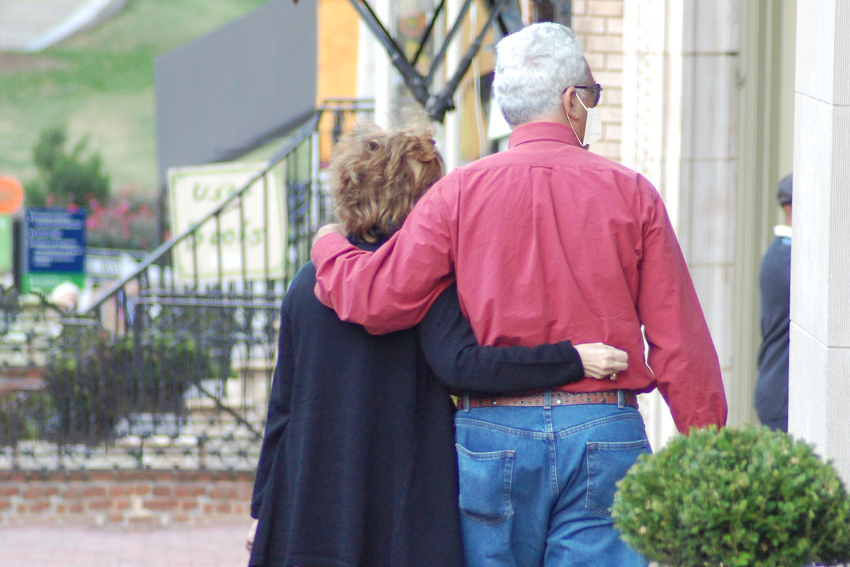 Older couple walking arm in arm down city street in Mount Vernon neighborhood of Baltimore