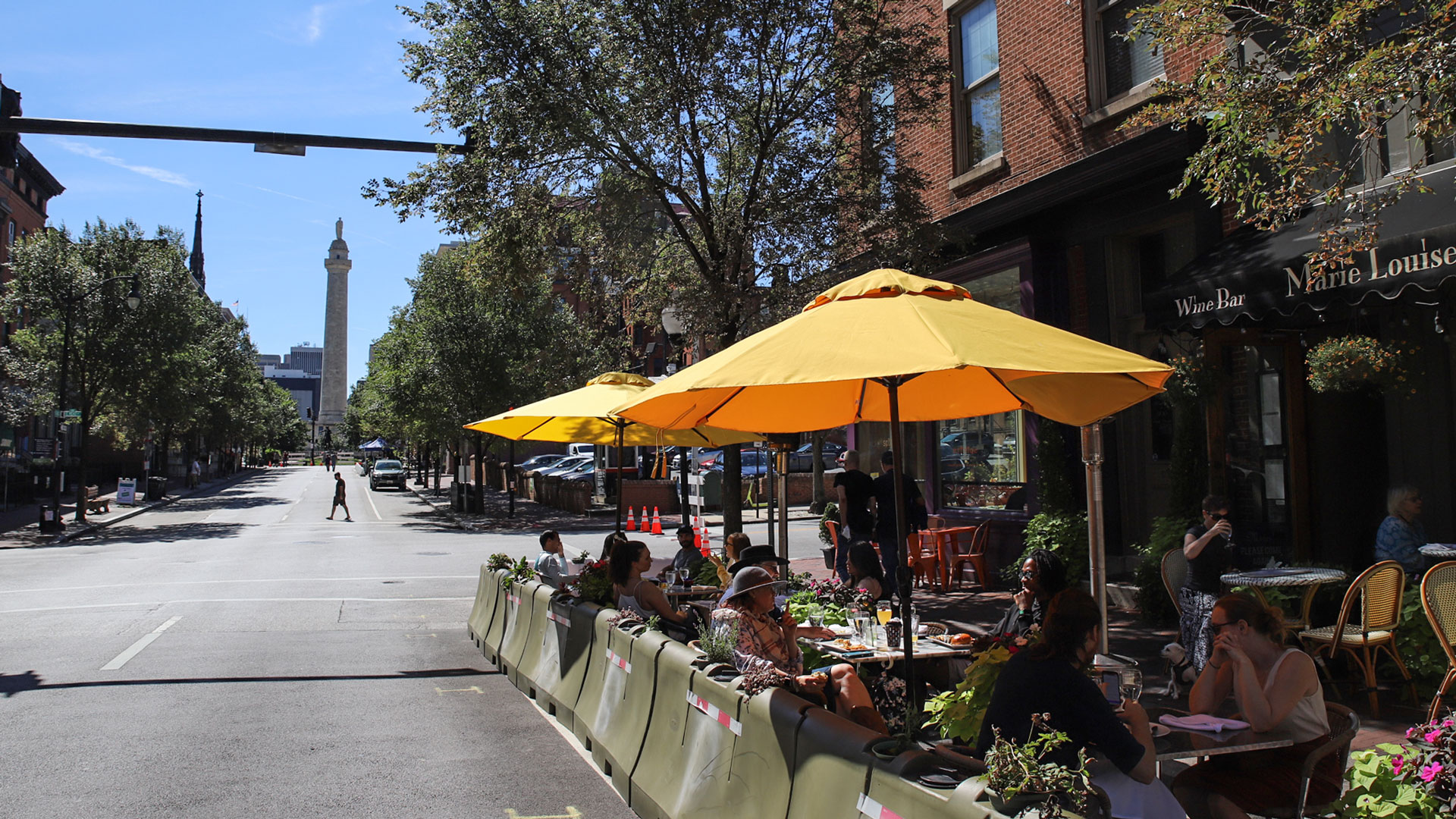 Outdoor dining at Marie Louise Bistro on Historic Charles Street with view of Washington Monument in the background. Baltimore, Maryland.