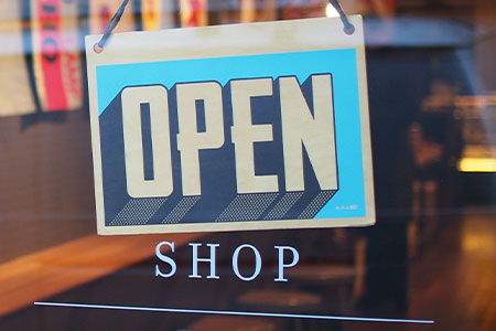 Small Business Assistance Package thumbnail image featuring storefront "open" sign.