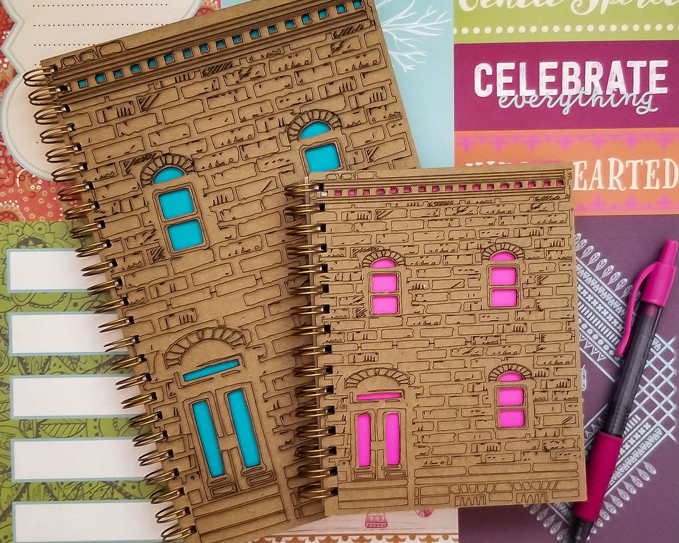 Notebooks with covers that look like Baltimore rowhomes by Drama MaMa Bookshop.