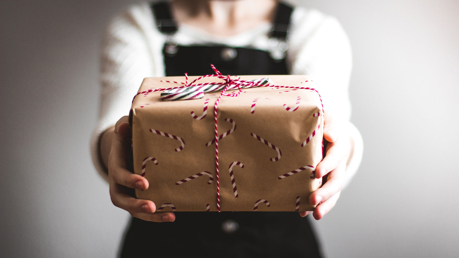 Woman holding a wrapped holiday gift.