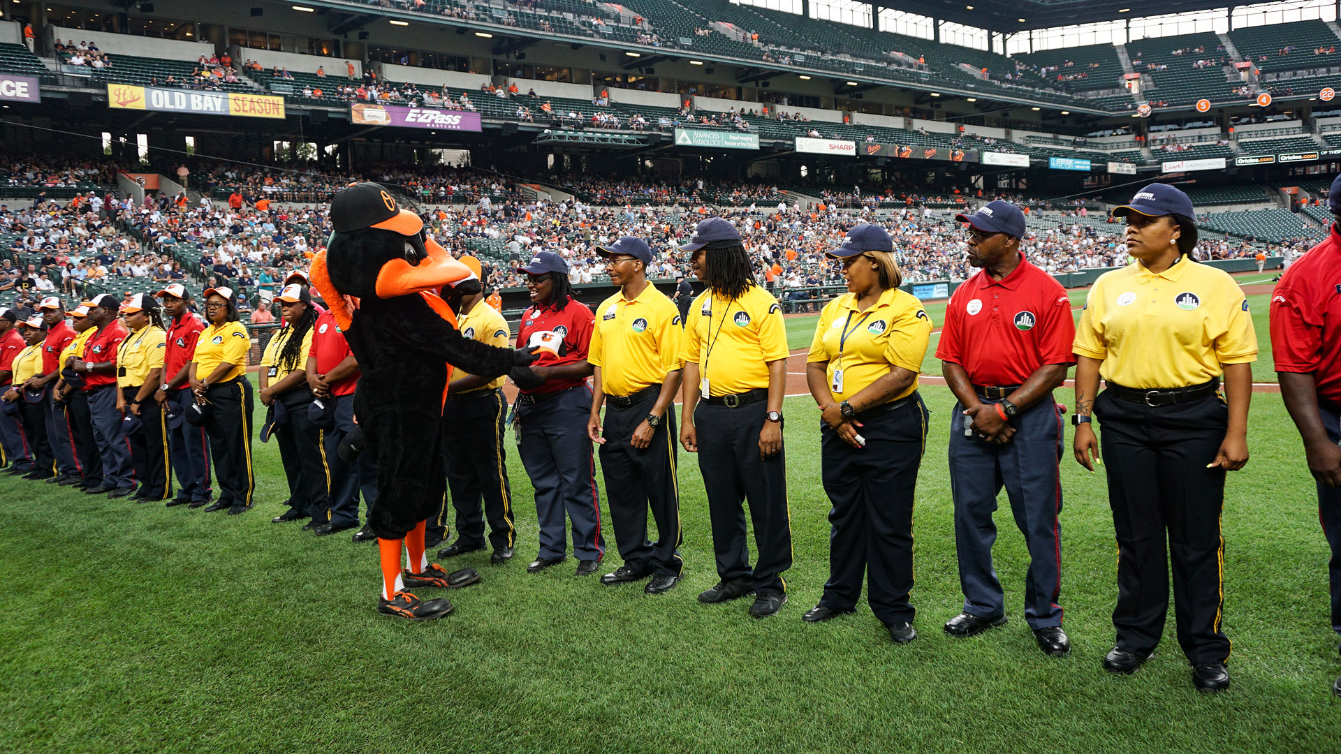 Downtown Partnership employees standing on the field at an Oriole's Game being recognized for their outstanding achievements.
