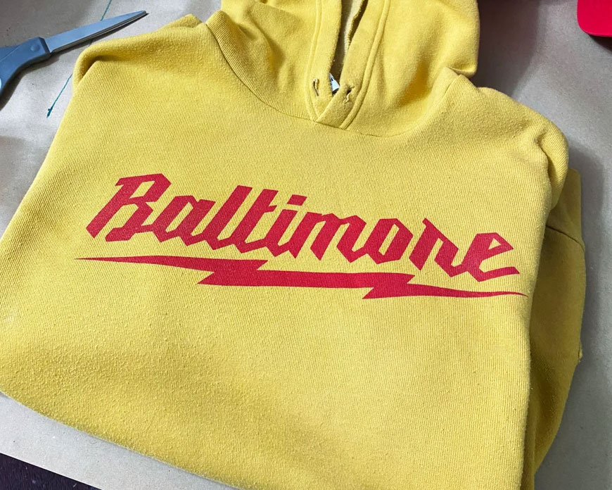 Yellow pullover hoodie that reads 